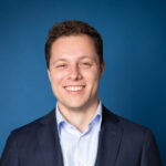 Foto van Onno James voor een blauwe achtergrond.