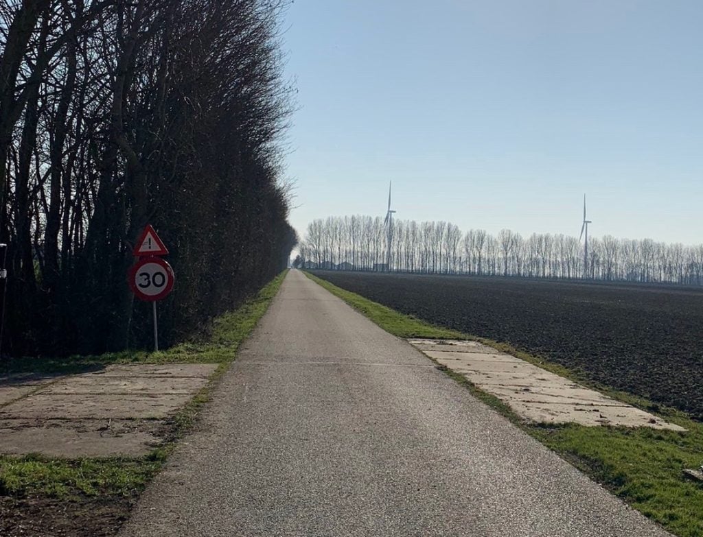 polderweg in de hoeksche waard met een 30 km bord en bomen aan 1 kant, weiland aan de andere kant. verkeersveiligheid hoeksche waard.