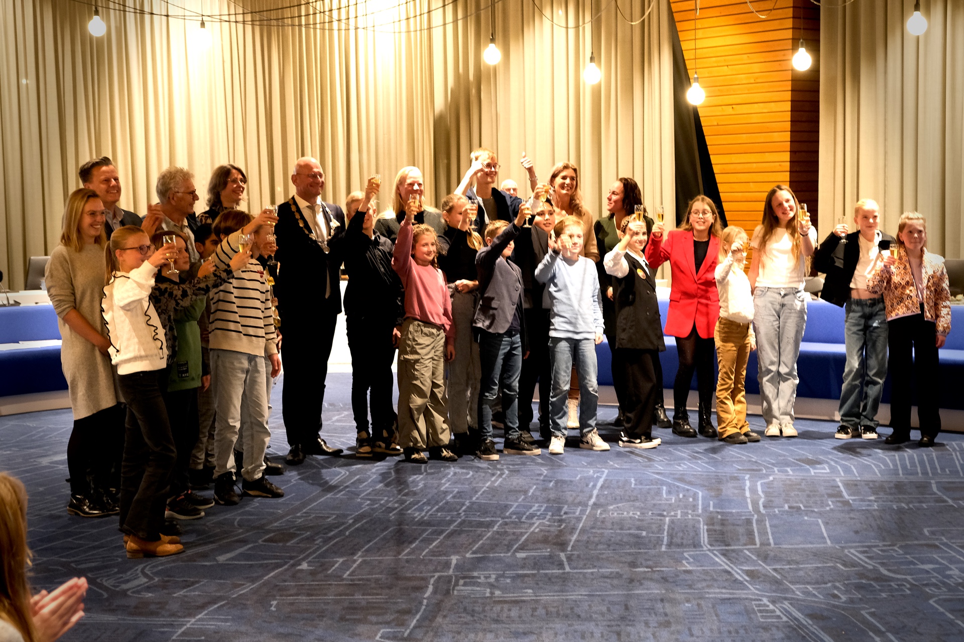 De kindergemeenteraad en de kinderburgemeester proosten op hun installatie