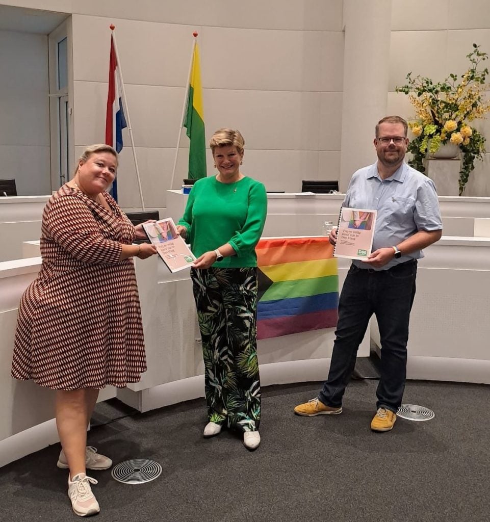 D66-raadleden Marije Mostert en Peter Mekers presenteren hun manifest ‘Vrij en veilig jezelf zijn in Den Haag’ aan wethouder Marielle Vavier in de gemeenteraad van Den Haag.