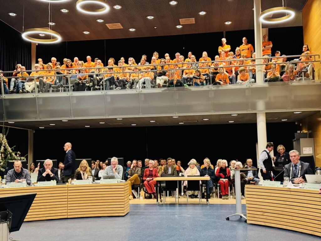 volle tribune in de raadszaal met deelnemers van de survival club Hang ON