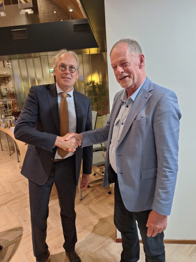 Wethouder Kees Bel feliciteert Cees Vis met de aangenomen motie